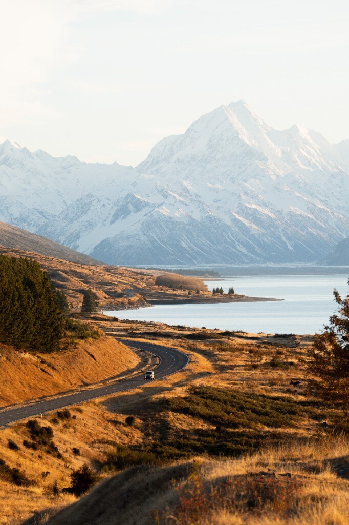 Jimny driving through snow at dusk, headlights on
